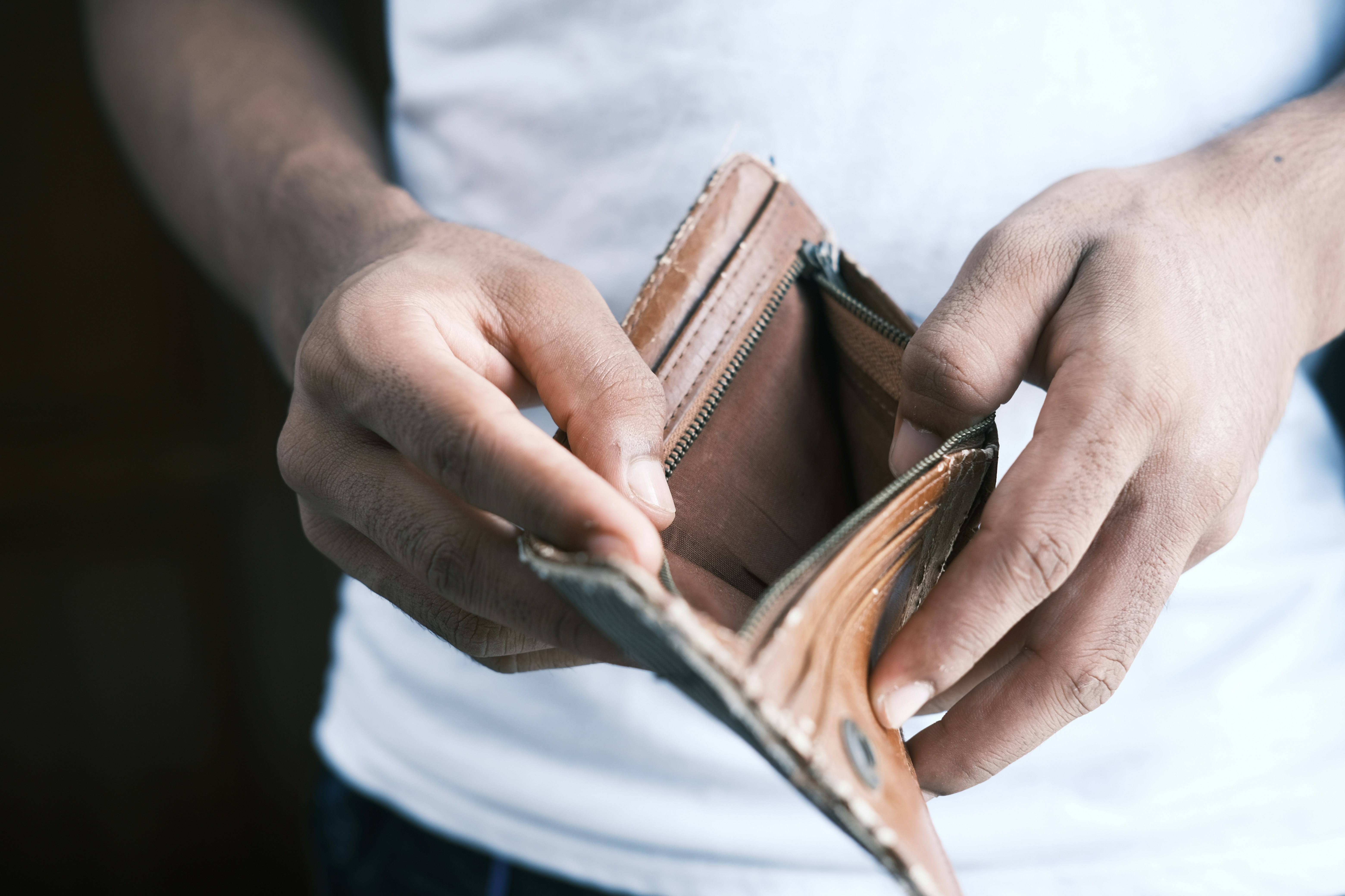 person holding a wallet with no money